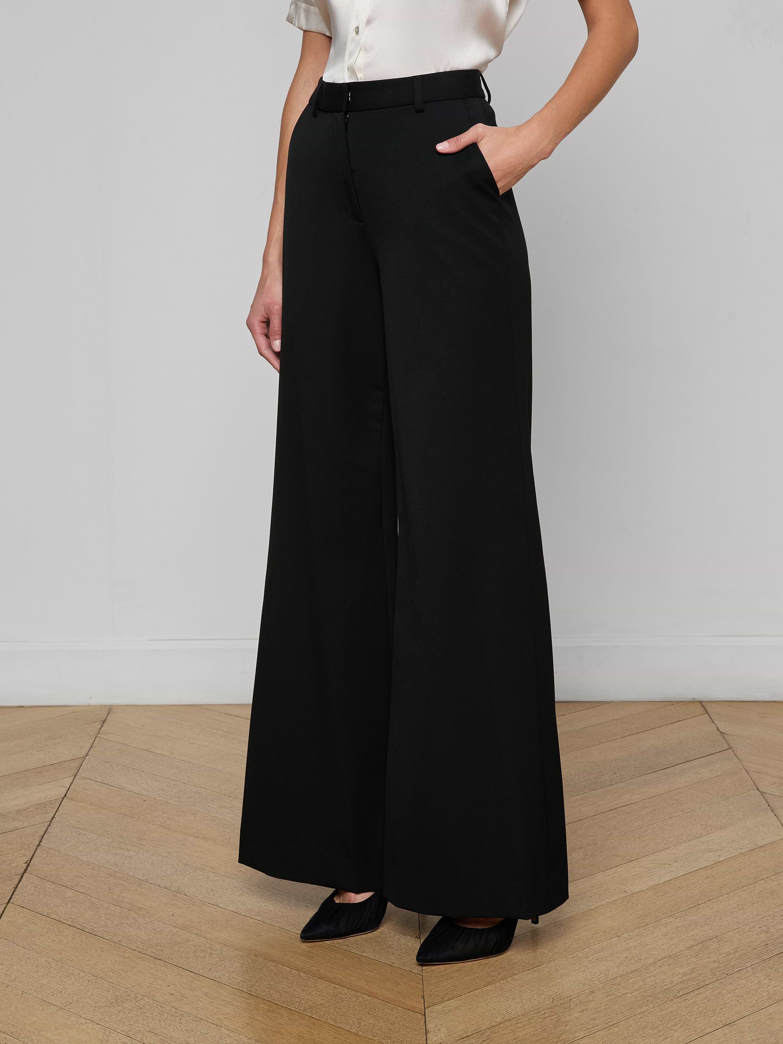 A person wearing the Pilar Wide-Leg Pant with a black belt and a white sleeveless top stands against a plain white background, showing only the lower half of their body.