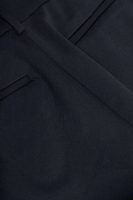 Close-up of a dark navy suit jacket, showcasing a lapel, pocket, and neatly pressed seam with fine fabric texture. Crafted from four-way stretch suiting, this style pairs perfectly with women’s trousers or the Pilar Wide-Leg Pant for a polished look.