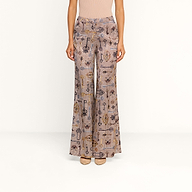 A person wears the Pilar Wide-Leg Pant, featuring a high-waisted brown houndstooth design, paired with a beige top and tan heels, standing against a plain white background.