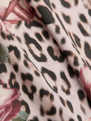 Close-up of beige, brown, and black rose cheetah print fabric with pink and green floral edges. The soft, smooth material is perfect for the Pilar Silk Wide-Leg Pant.