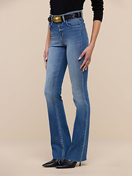 Person wearing Ruth Straight-Leg Jean in light blue, crafted from premium stretch denim. Paired with a black top, black belt, and black pointed shoes. The background is plain white, and only the lower half of the body is visible.