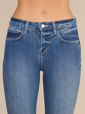 Nahaufnahme einer Person, die die „Ruth Straight-Leg Jean“ in klassischem Indigo trägt, mit Knopf- und Reißverschluss, Bund, Taschen und Oberschenkeln, vor einem neutralen Hintergrund.