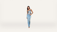 Woman stands facing forward, wearing a blue patterned sleeveless top, light blue jeans, and heels, with one hand in her pocket against a plain white background.