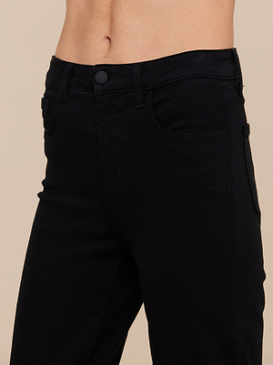 A close-up of a person wearing the Ruth Straight-Leg Jean in black stretch denim, highlighting the high-rise waistband, front pockets, and button closure against a plain beige background.