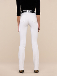 A person stands facing away against a plain white background, wearing the Ruth Straight-Leg Jean in white with a high-rise fit and slim straight leg, styled with a black belt, black long-sleeve top, and black-heeled shoes.