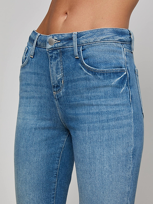 Close-up of a person wearing the Ruth Straight-Leg Jean by L'AGENCE, featuring high-waisted, light blue stretch denim with a button and zipper front, straight-leg style, shown from the waist to upper thighs against a plain background.