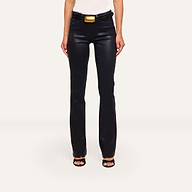 A person wears Ruth Coated Straight-Leg Jean in black, paired with a black belt featuring a large gold buckle, black heeled sandals, and a white top, standing against a plain white background.