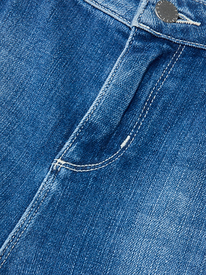 Close-up of the Ruth Straight-Leg Jean in blue denim, featuring the waistband, metal button, pocket, visible stitching details, and a raw hem.