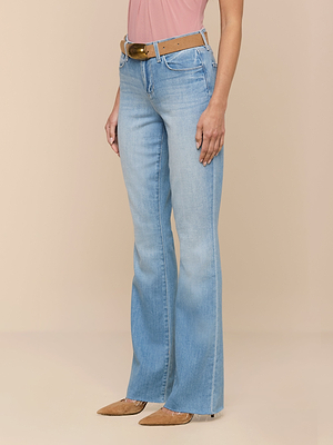 A person wearing Ruth Straight-Leg Jeans in light indigo wash, a light brown belt, a pink sleeveless top, and tan pointed-toe shoes stands against a beige background.