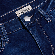 Close-up of the Kendra Cropped Flare Jean in dark blue, featuring a high rise, silver button, front pocket, visible stitching, and a white LAGENCE fabric label above the waistband. Made from super stretch denim for a comfortable fit.