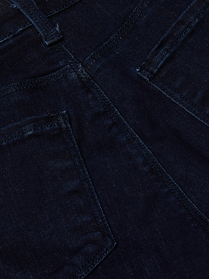 Close-up of the back pockets and waistband of L'AGENCE Kendra Cropped Flare Jean in dark indigo wash, highlighting stitching details and fabric texture.