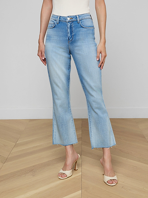 Wearing the Kendra Cropped Flare Jean with frayed hems and a white sleeveless top, this look is styled effortlessly with beige open-toe heeled sandals on a light wood floor. The Kendra adds a trendy twist to any outfit.