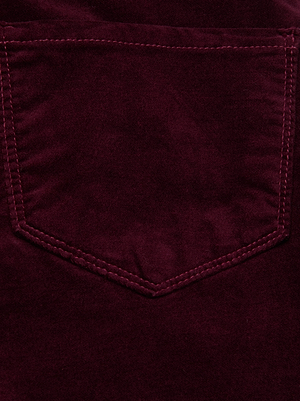 Close-up of the Stevie Velvet Jean by L'AGENCE, showing dark maroon stretch velvet with visible pocket stitching. The fabric's soft, smooth texture and sheen highlight its rich color.