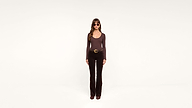A woman with long brown hair, wearing sunglasses, a brown long-sleeve shirt, black pants, and brown shoes, stands facing forward against a plain white background.