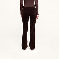 A person is shown from the back, standing against a plain white background, wearing the Stevie Velvet Jean in dark java brown—a stretch velvet pant with a slim straight leg—paired with a matching long-sleeve top.