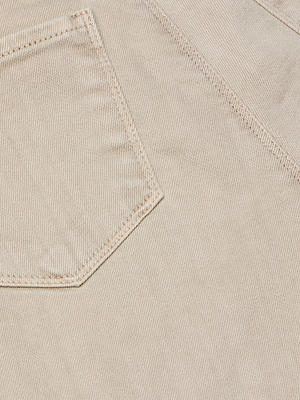 Close-up of light beige stretch denim with visible weave, diagonal threads, and clear stitching on a pocket—showing the signature detailing of the Selma Bootcut Jean.