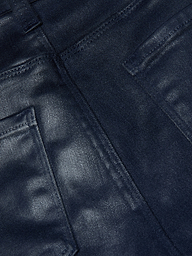 Close-up of the Selma Coated Bootcut Jean in dark blue, featuring detailed stitching and the edges of two back pockets, highlighting the texture and weave of its leather-alternative denim fabric.