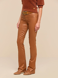 A person is wearing dark java brown Selma Coated Bootcut Jeans styled in a bootcut silhouette, paired with a brown short-sleeve top, a brown belt, and brown suede shoes, standing against a plain white background. The upper head is not visible in the image.