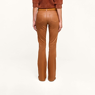 A person models the Selma Coated Bootcut Jean in a high-waisted, camel hue, paired with a dark java brown top, photographed from the back against a plain white background.