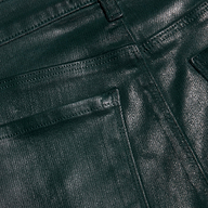 Close-up of the Selma Coated Bootcut Jean in dark green, highlighting the textured coating, detailed stitching, and upper section of the front pocket and belt loop.