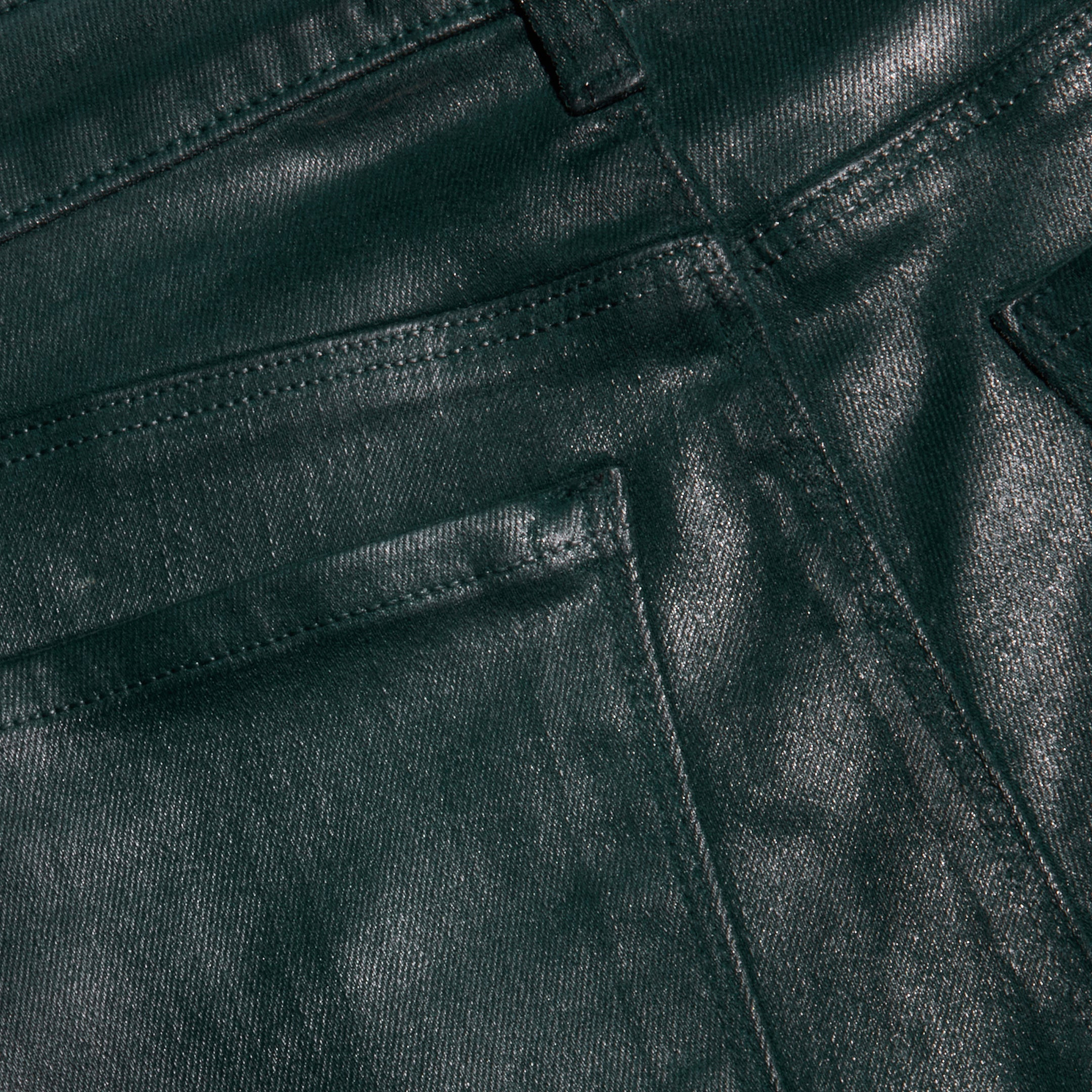 Close-up of the Selma Coated Bootcut Jean in dark green, highlighting the textured coating, detailed stitching, and upper section of the front pocket and belt loop.