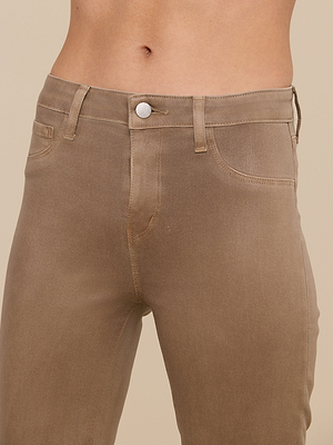 A close-up of a person wearing the Selma Coated Bootcut Jean in light brown, highlighting the high-rise waistband, button, belt loops, and front pockets against a plain beige background.