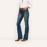 Selma Embellished Bootcut Jean in blue, featuring gold-toned floral embellishments and crystal details on the hips, paired with a white button-down shirt and brown pointed-toe heels.