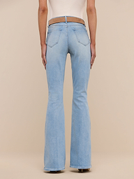 A person wearing the Marty Flare Jean in light blue with a beige top, shown from the back and standing against a plain white background.