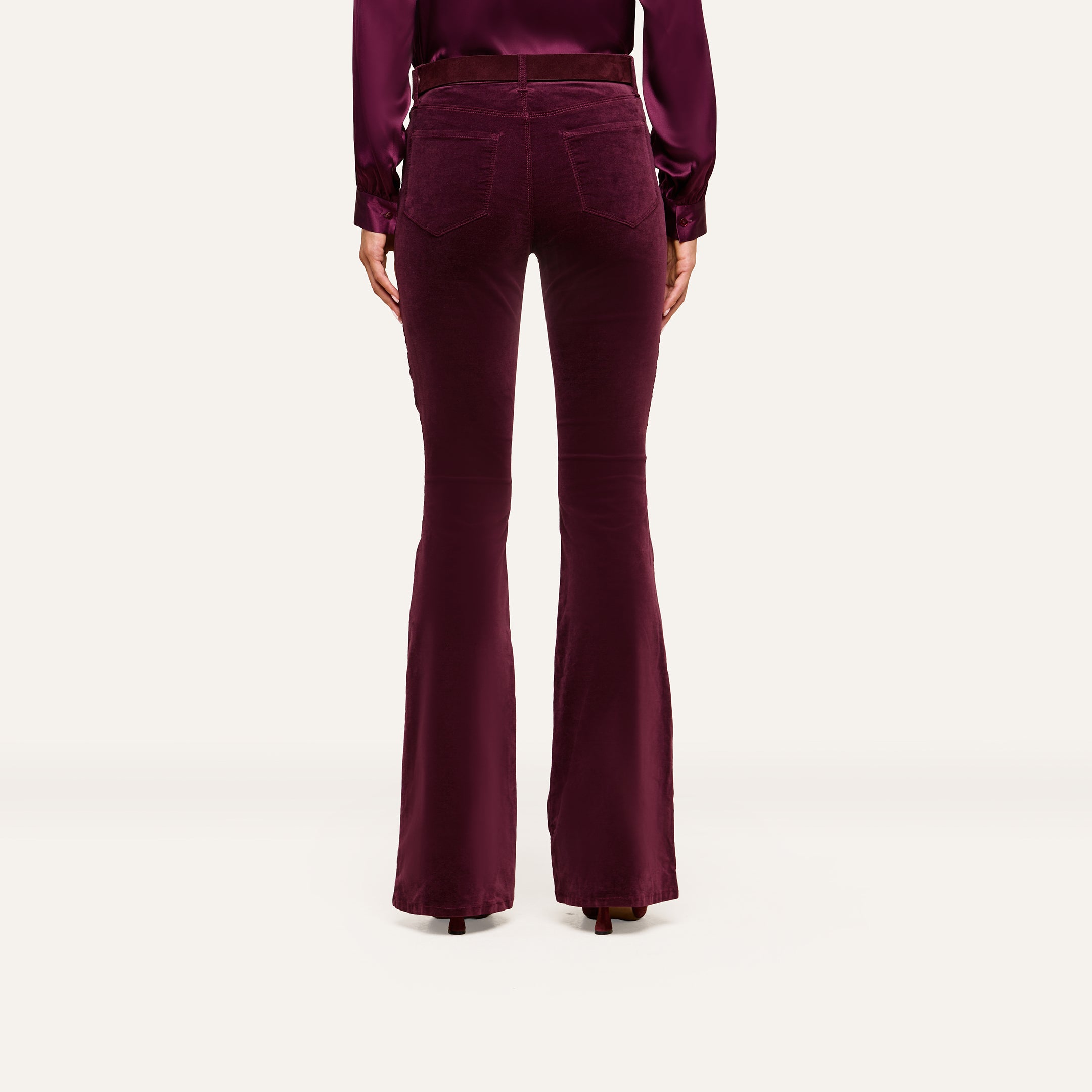 Model shown from the back against a plain light background, wearing the Marty Velvet Pant in burgundy with a matching long-sleeve blouse.