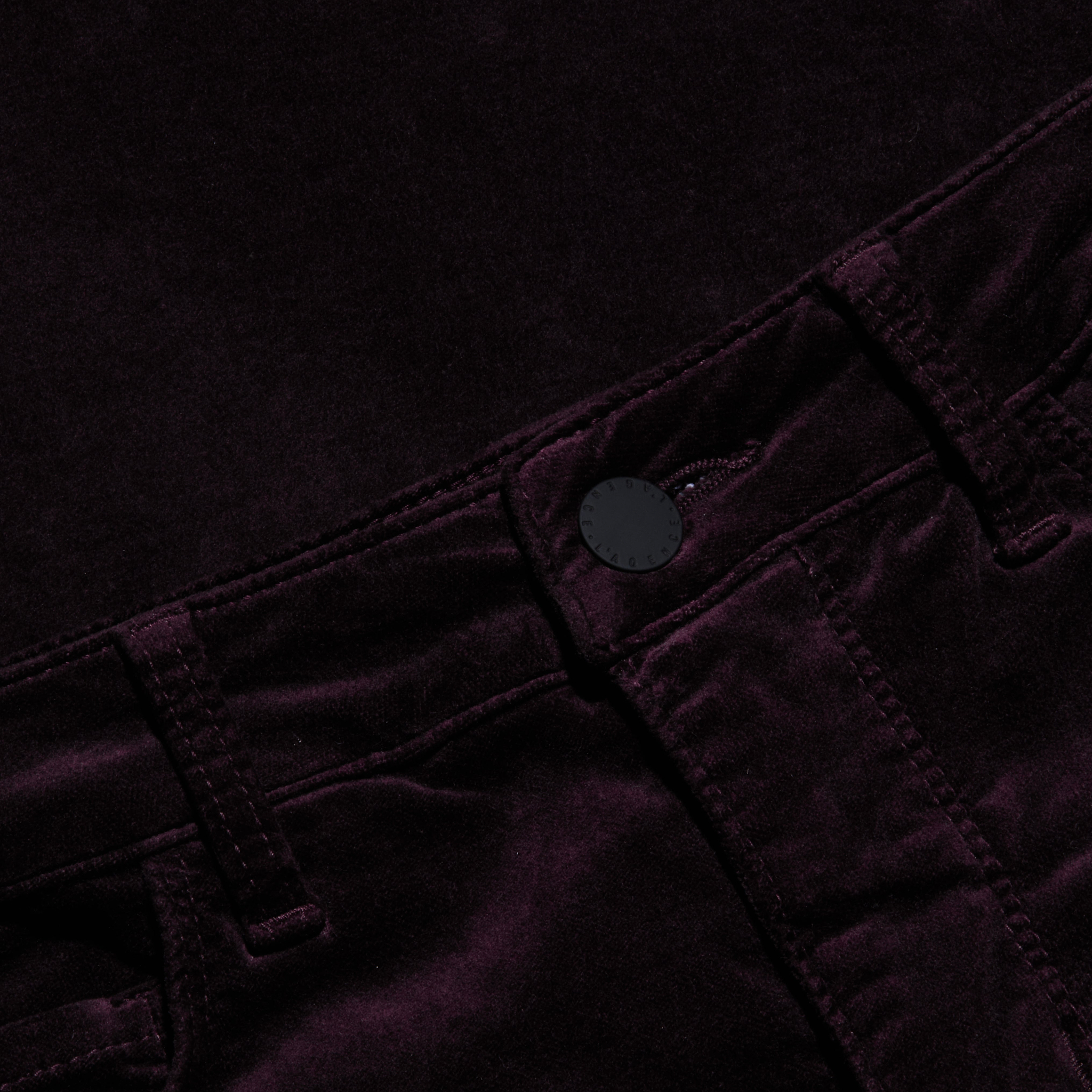 Close-up of the Marty Velvet Pant in a dark purple or black shade, highlighting the high rise waistband, belt loops, button closure, and detailed stitching.
