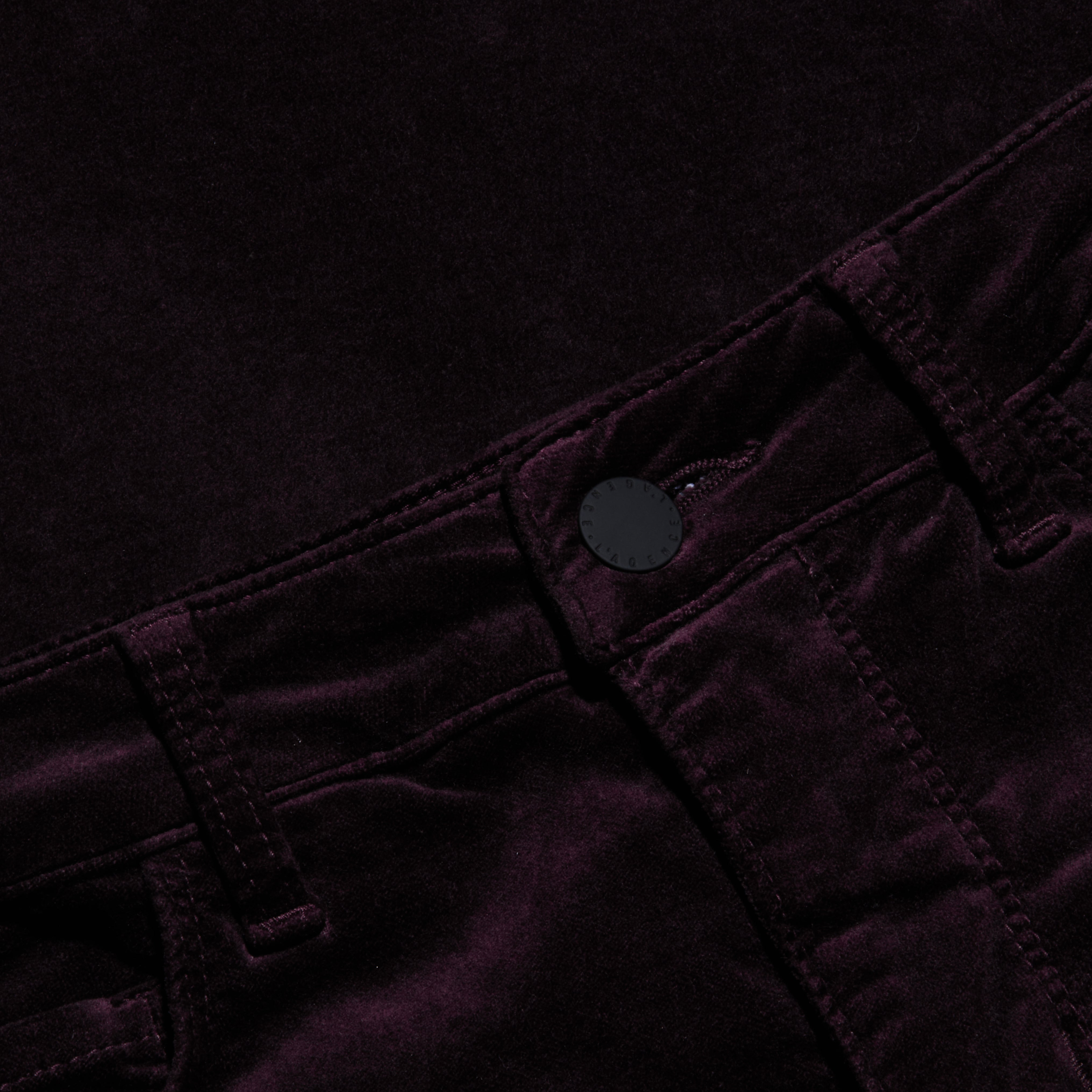 Close-up of the Marty Velvet Pant in a dark purple or black shade, highlighting the high rise waistband, belt loops, button closure, and detailed stitching.