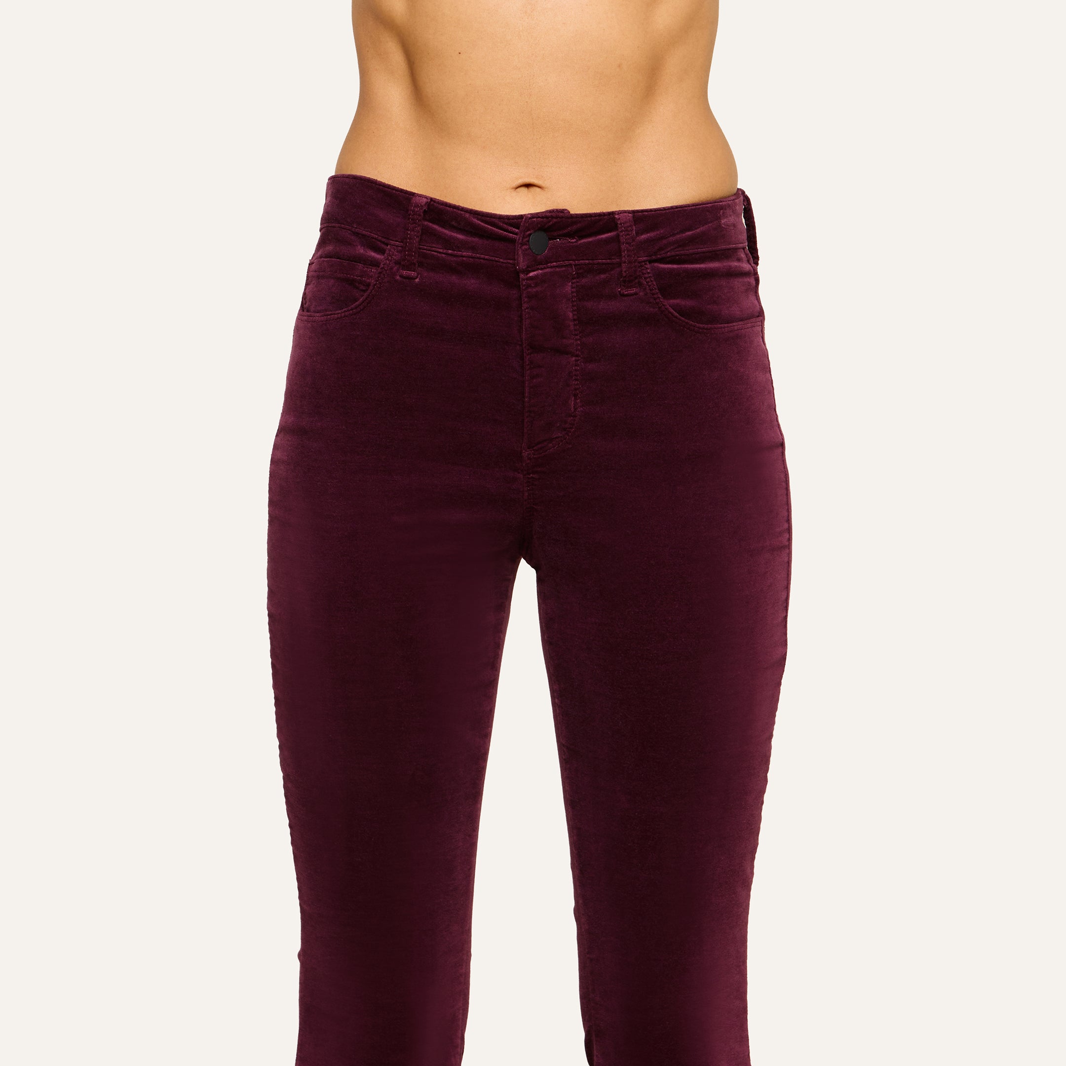 A person wearing the Marty Velvet Pant, a pair of high-waisted dark burgundy pants with a flattering rise, shown from mid-torso to mid-thigh against a plain background.