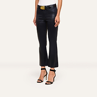 A person wears Kendra Coated Cropped Flare Jean, a white top, a black belt with a gold buckle, and black high-heeled sandals, standing against a plain light background.