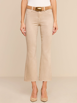 A person wearing the Kendra Coated Cropped Flare Jean, paired with a light brown belt featuring a gold buckle and beige high-heeled shoes, stands against a plain beige background.