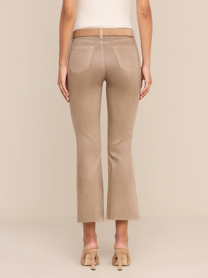 On voit une personne de dos, debout devant un fond beige uni, chaussée de sandales à talons hauts et vêtue dun jean évasé court enduit « Kendra » de couleur beige.