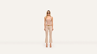 A woman in sunglasses, a beige tank top, beige pants, and heels stands confidently against a plain white background.