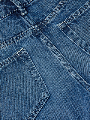 Close-up of Milana Slouchy Stovepipe Jean by L'AGENCE in vintage-wash blue denim, featuring all-cotton fabric, detailed stitching, and two front pockets with visible seams.