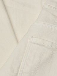 Close-up of the Wanda Cropped Wide-Leg Jean in a lightweight ecru-wash denim, highlighting stitched seams, a folded edge, and part of the pocket. The image showcases the fabric’s texture and weave in detail.