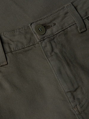 Gros plan sur la ceinture et la poche avant du jean court à jambes larges Wanda en vert olive, mettant en valeur le bouton, le passant de ceinture et les coutures détaillées sur le tissu.
