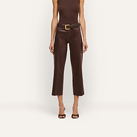 A woman stands against a plain white background wearing a sleeveless dark java brown top, open-toed heels, and the Wanda Coated Cropped Wide-Leg Jean with a wide belt.
