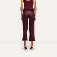 A woman is shown from the back, standing against a plain light background, wearing a sleeveless burgundy top, matching high heels, and the Wanda Coated Cropped Wide-Leg Jean in burgundy.