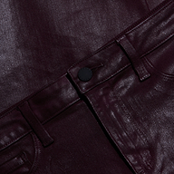 Close-up of the Wanda Coated Cropped Wide-Leg Jean in metallic burgundy, highlighting the shiny textured fabric along the waistband, belt loops, button, and part of the front pockets.