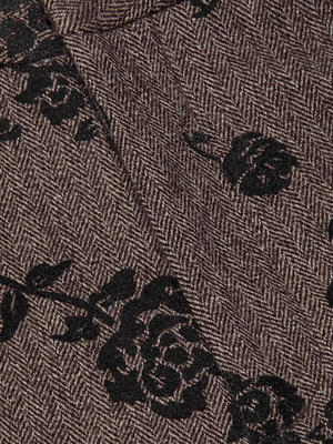 Close-up of the Rebel Flocked Trouser by L'AGENCE, featuring brown wool-blend herringbone fabric with black rose floral designs—perfect for crafting stylish, high-rise, straight-leg trousers.