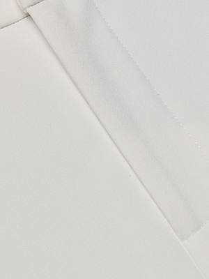 Close-up of the Rebel Trouser in white stretch suit fabric, featuring clean, straight seams and a visible pocket, suggesting a tailored high-rise, straight-leg design.