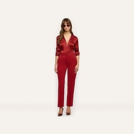 A person wearing a long-sleeved red button-down shirt tucked into slim-straight Rebel Trouser trousers and red pointed-toe heels, creating a tailored statement look.