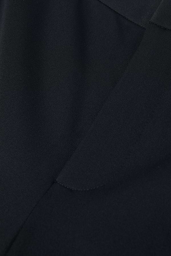 Close-up of the Rebel Trouser in dark navy blue, crafted from Italian stretch suiting, highlighting the fabric texture and edge detailing.