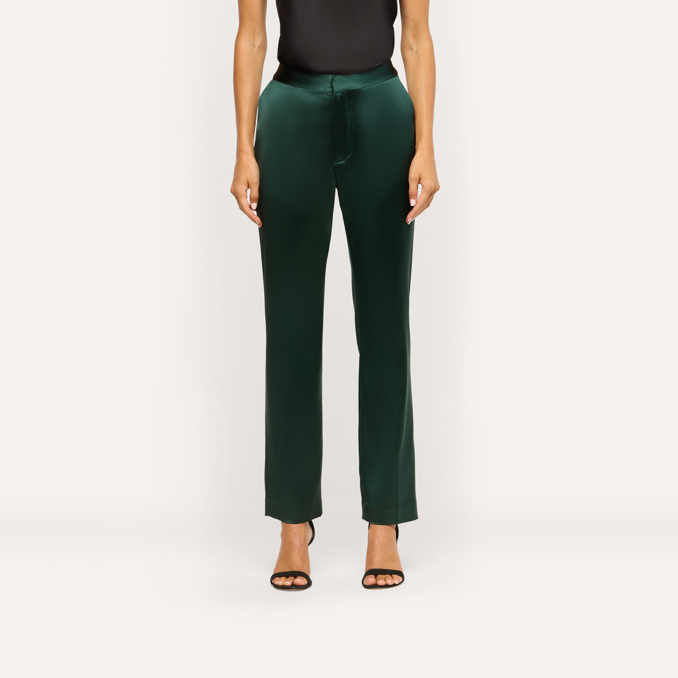 Dark green Rebel Satin Trouser in a slim-straight fit with a flat waistband, worn with a black top and black heeled sandals for a tailored statement.