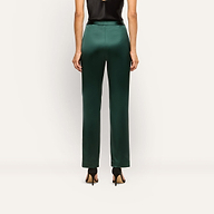 Back view of a person wearing dark green slim-straight Rebel Satin Trousers and black high-heeled sandals.