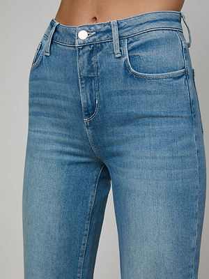 Close-up of a person wearing the Clayton Wide-Leg Jean in light blue denim, highlighting the high-rise waistband, front pockets, and zipper area against a plain, neutral background.