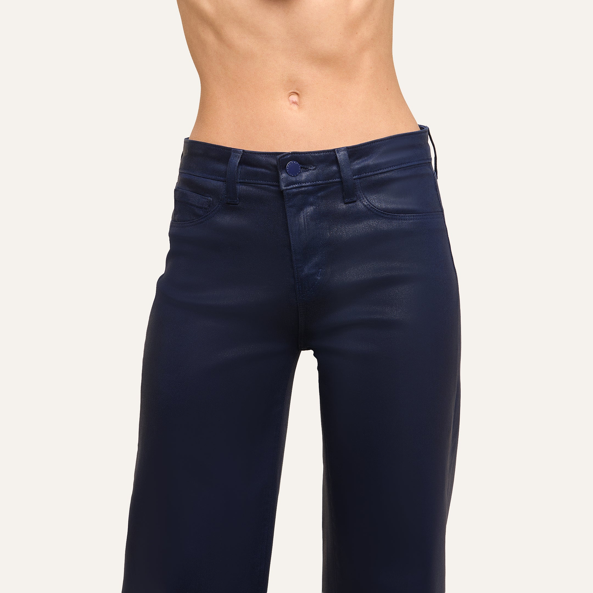 A person wearing Clayton Coated Wide-Leg Jean in dark blue stands against a plain background, displaying their midsection and part of their legs.